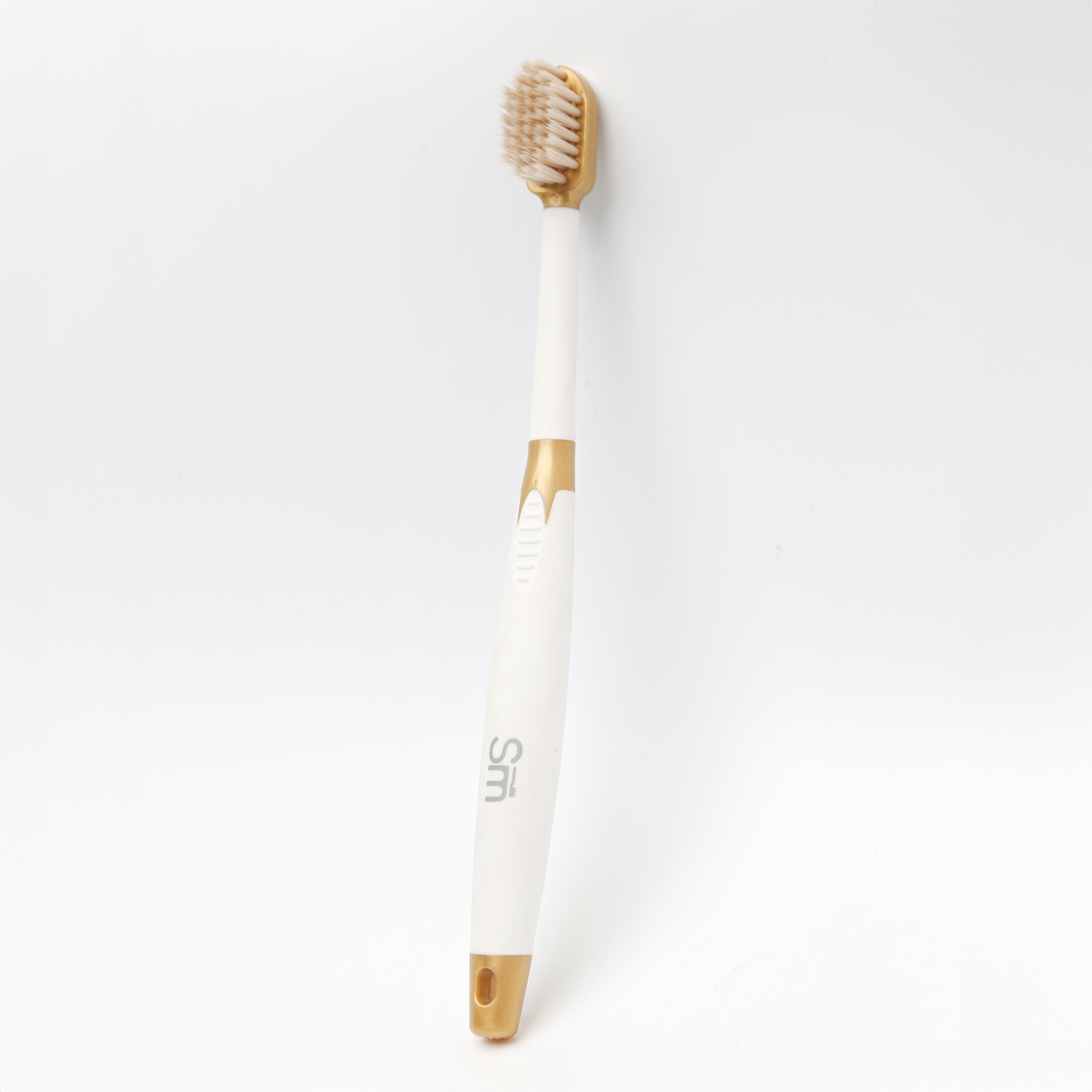 White toothbrush with gold accents on a white background