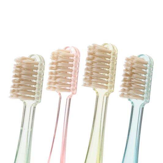 Four pastel-colored toothbrush heads on a white background