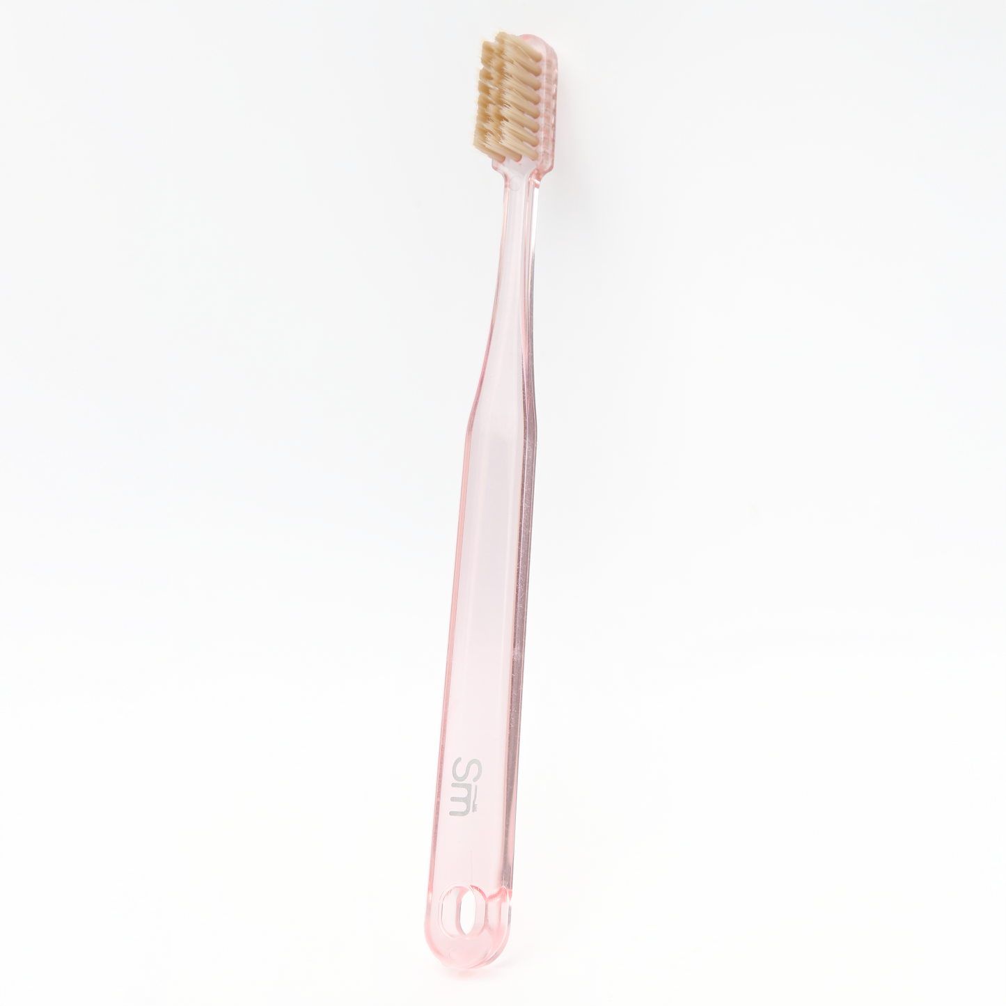 Pink toothbrush with beige bristles on a white background