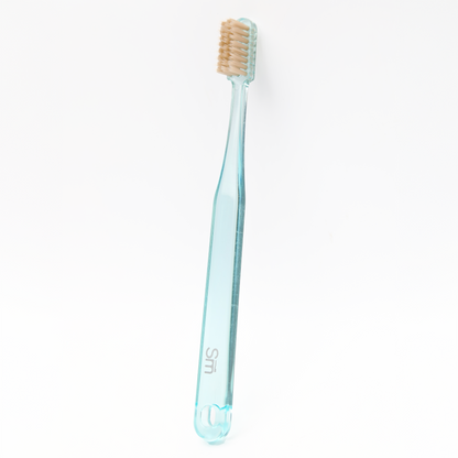 Light blue toothbrush with brown bristles on a white background