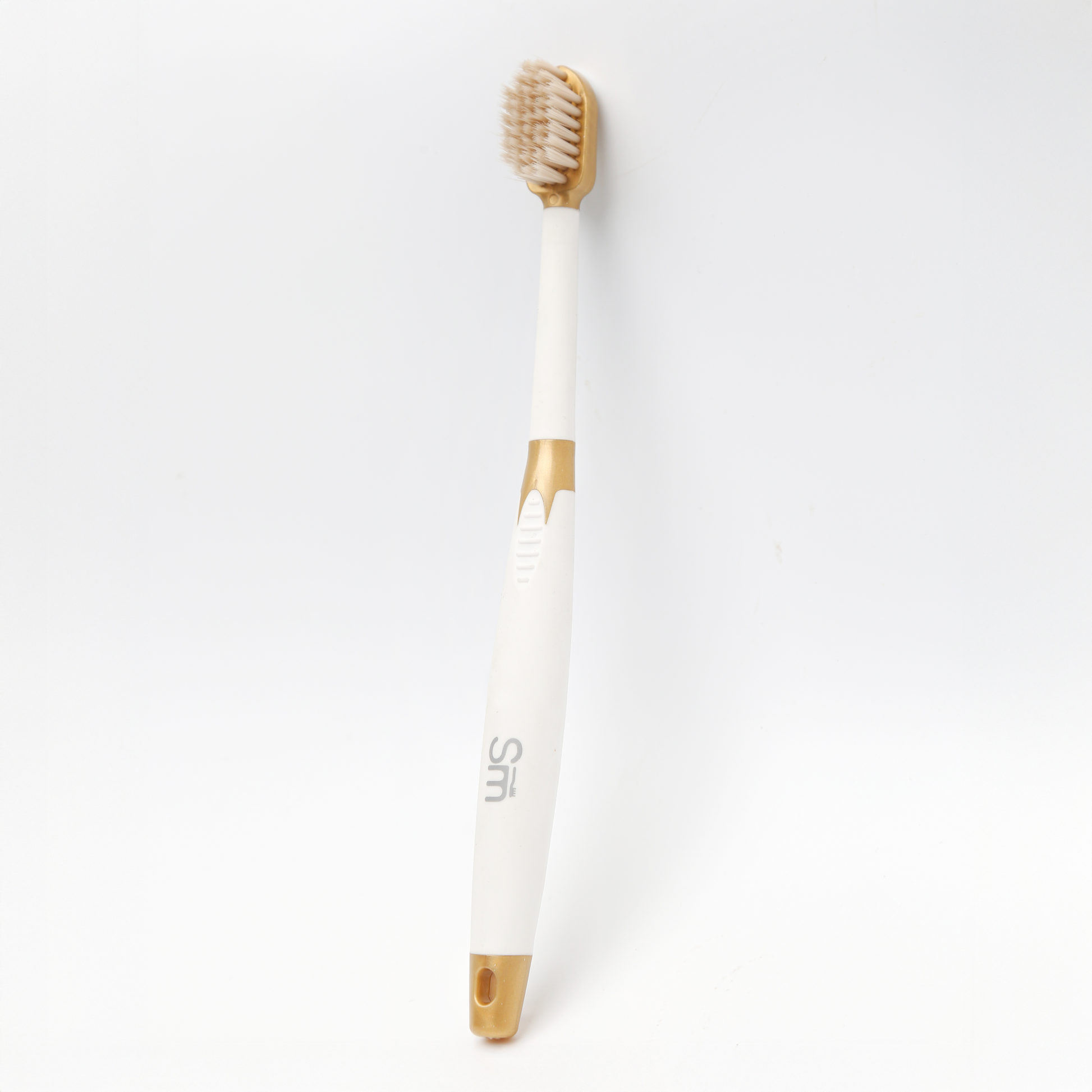 White toothbrush with gold accents on a white background