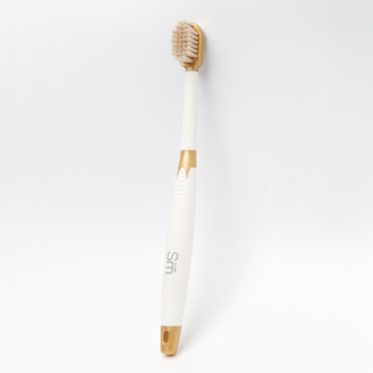 White toothbrush with gold accents on a white background