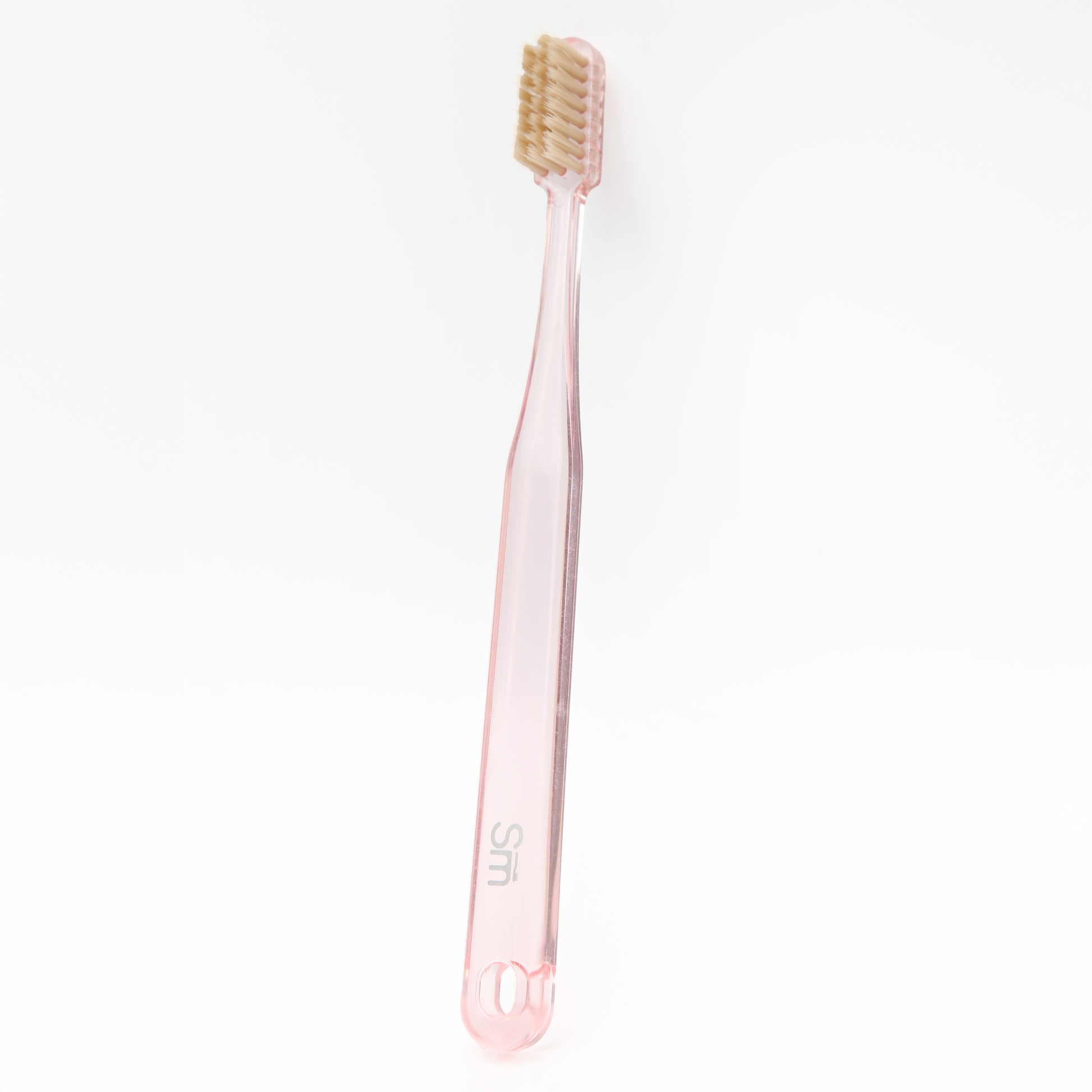 Pink toothbrush with beige bristles on a white background