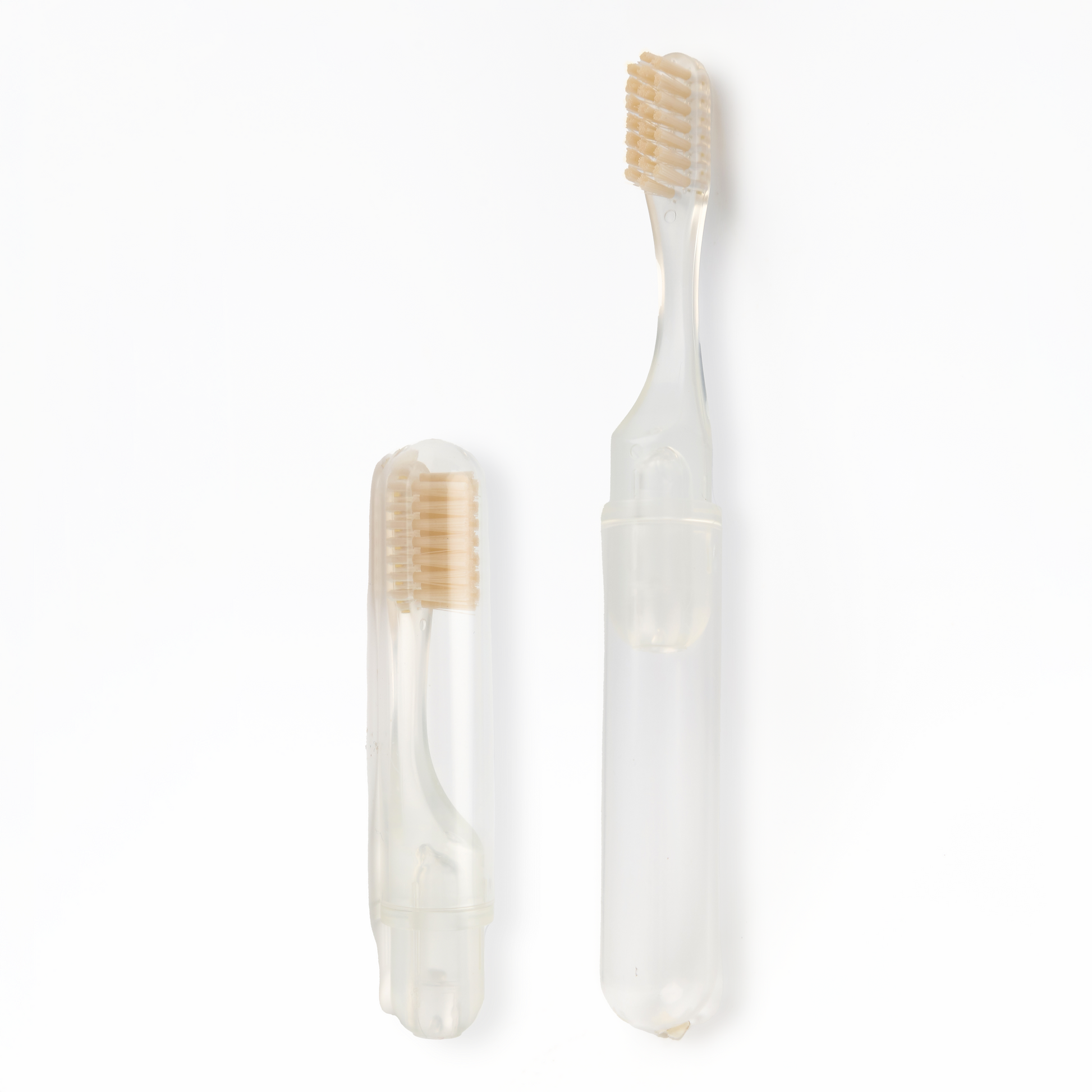 Transparent toothbrush with beige bristles on a white background